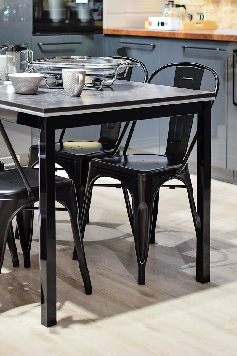 Stylish modern kitchen featuring a black metal dining table with chairs and sleek cabinetry.